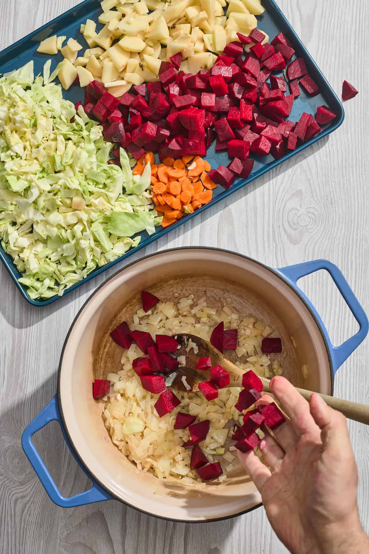 vegetables being added to a pan