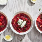 bowls of borscht with eggs and sour cream
