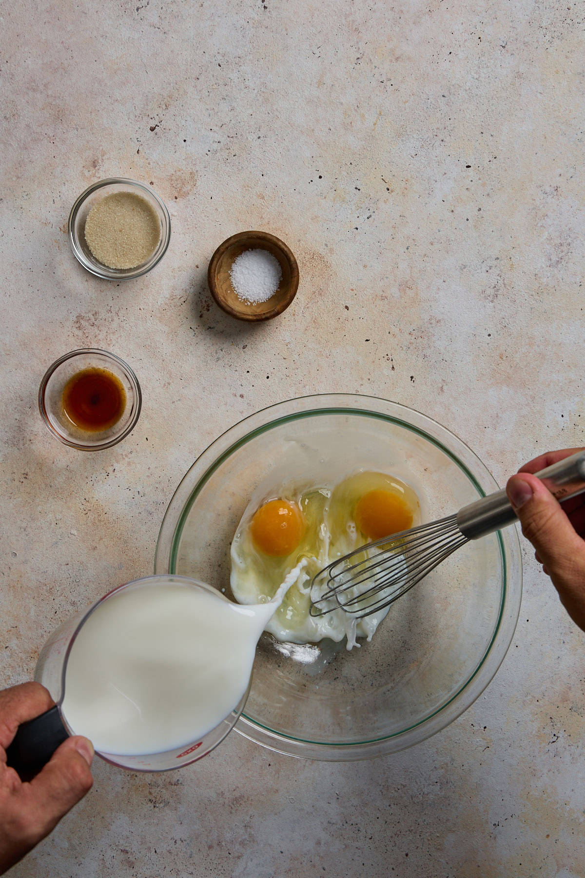 milk being whisked into eggs in a bowl 