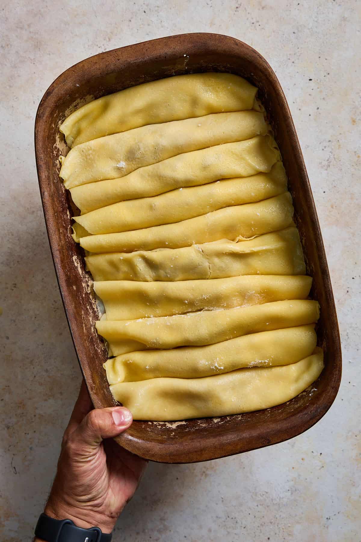 a baking dish full of stuffed crepes