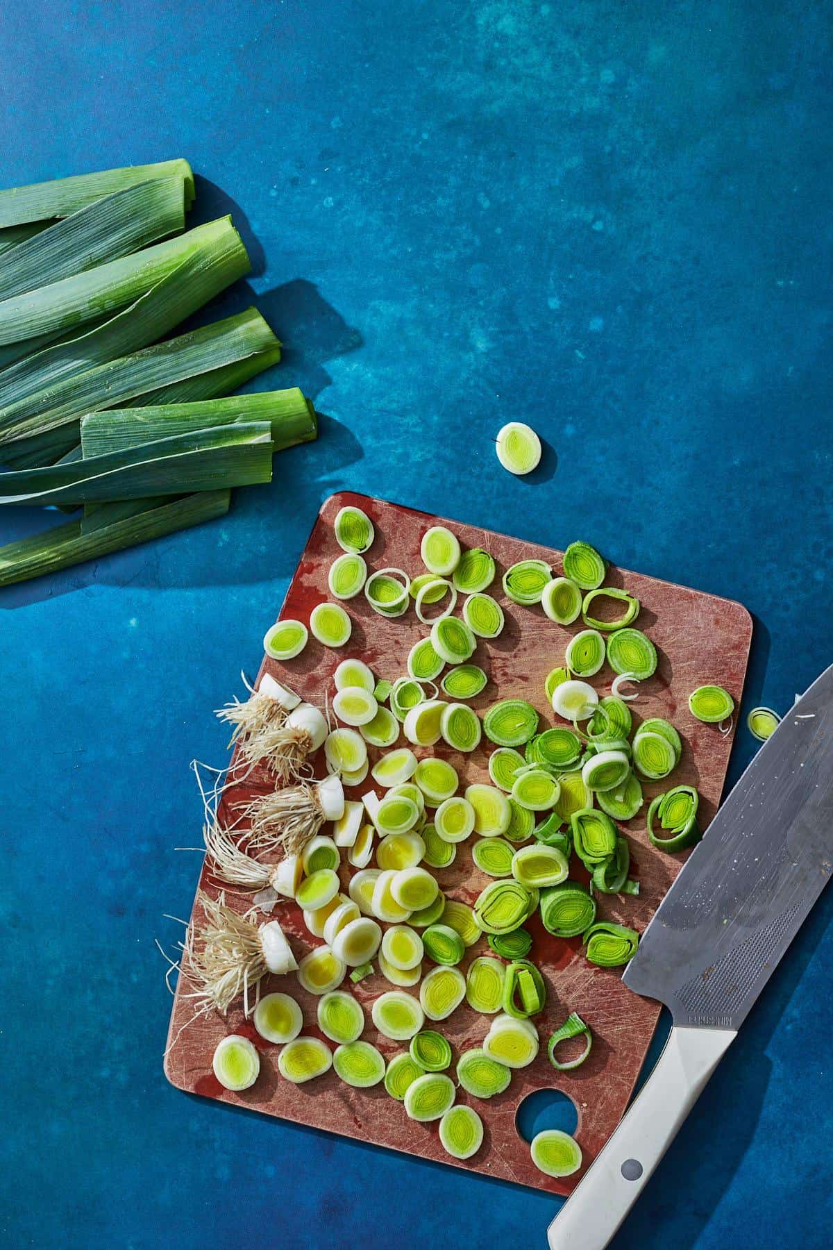 leeks sliced on cutting board with knife
