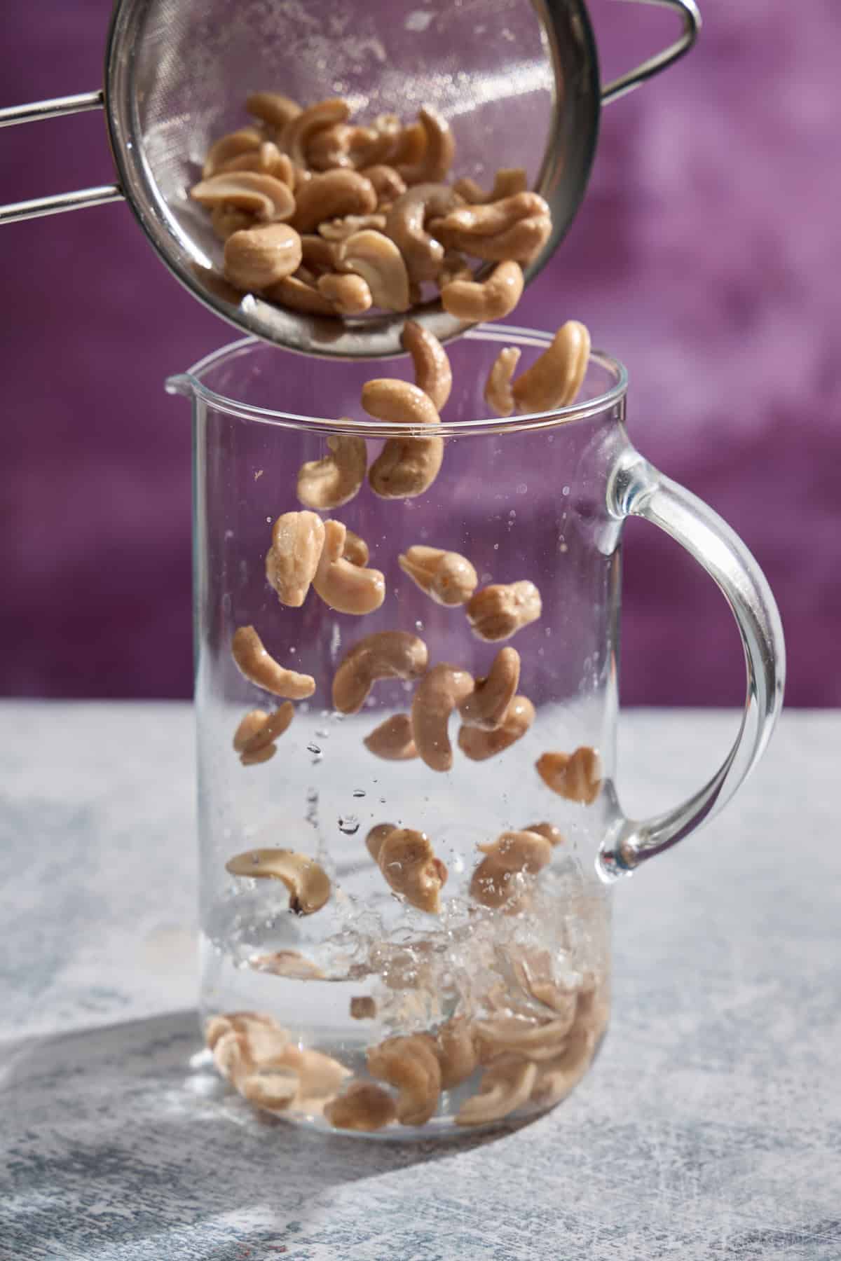 cashews being added to a pitcher