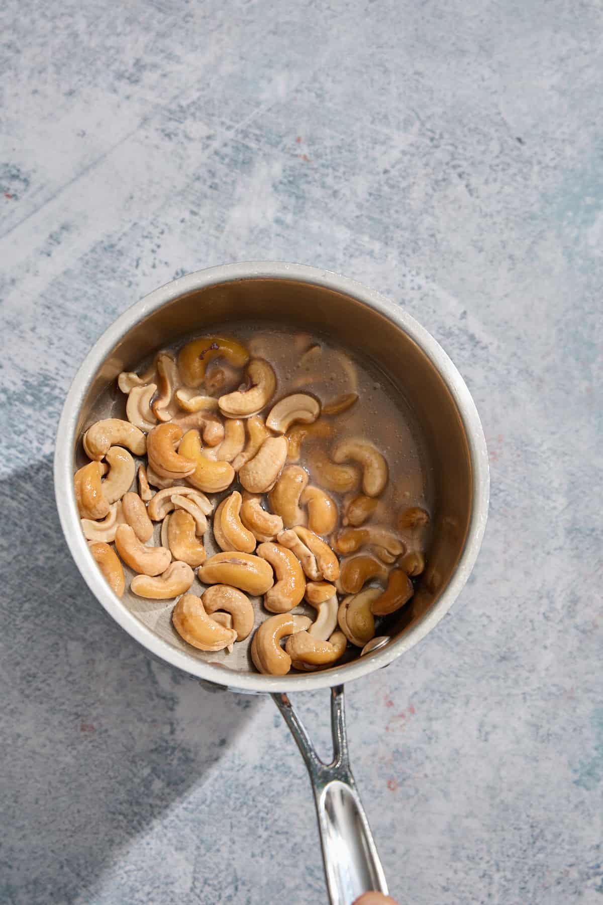 cashews in a pan that have been simmered in water