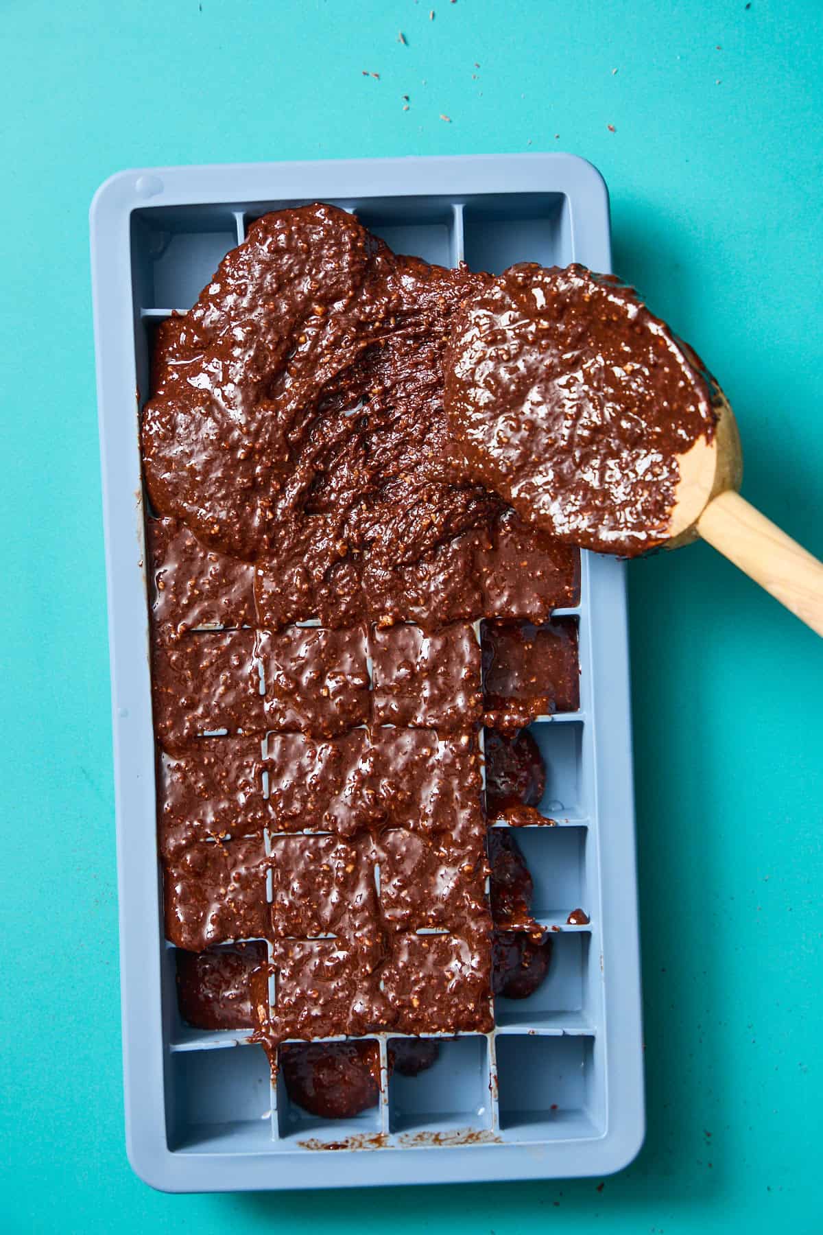 chocolate mixture being spread into an ice cube tray