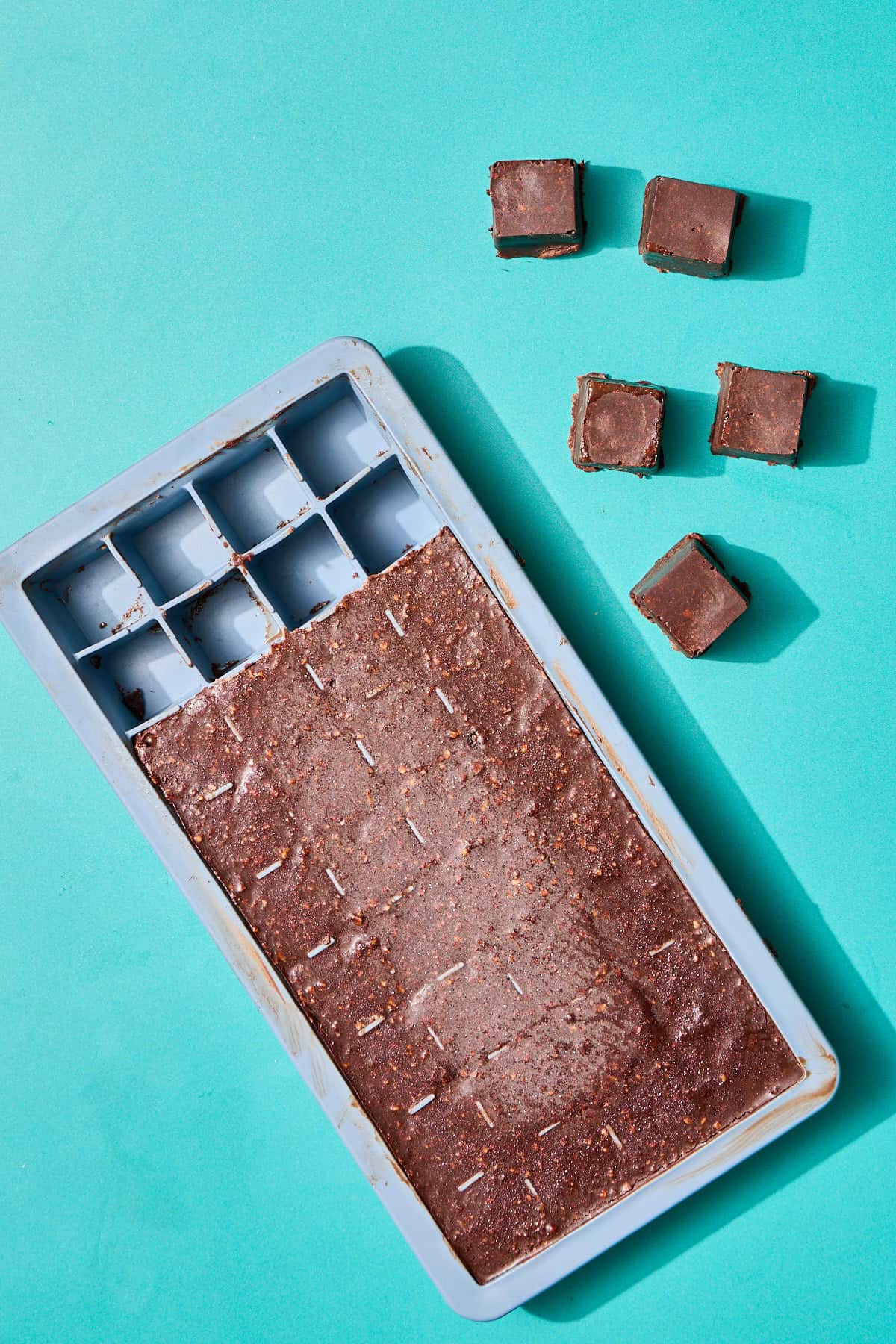 chocolates being popped out of the ice cube tray mold
