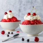 granita in bowls with whipped cream and cherries