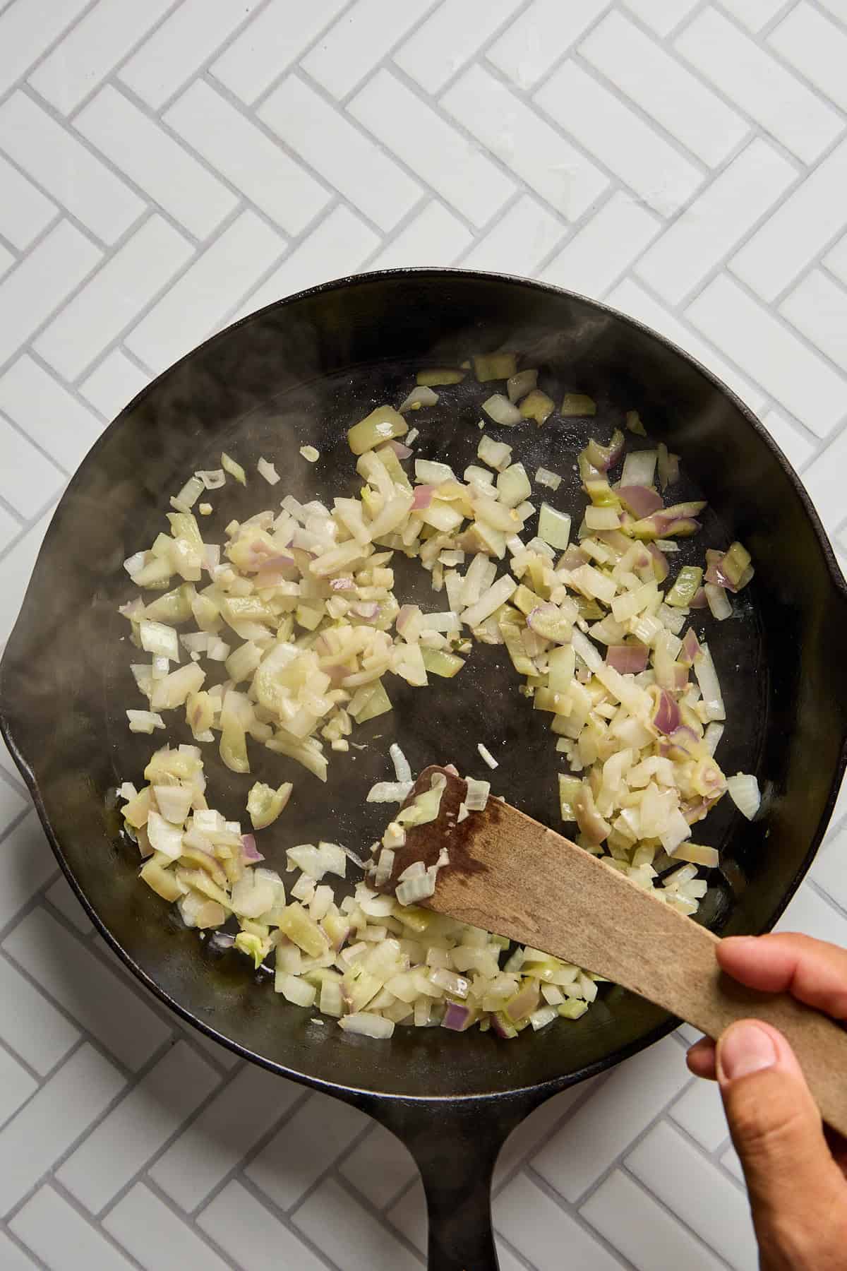 onions and peppers sauteeing in pan