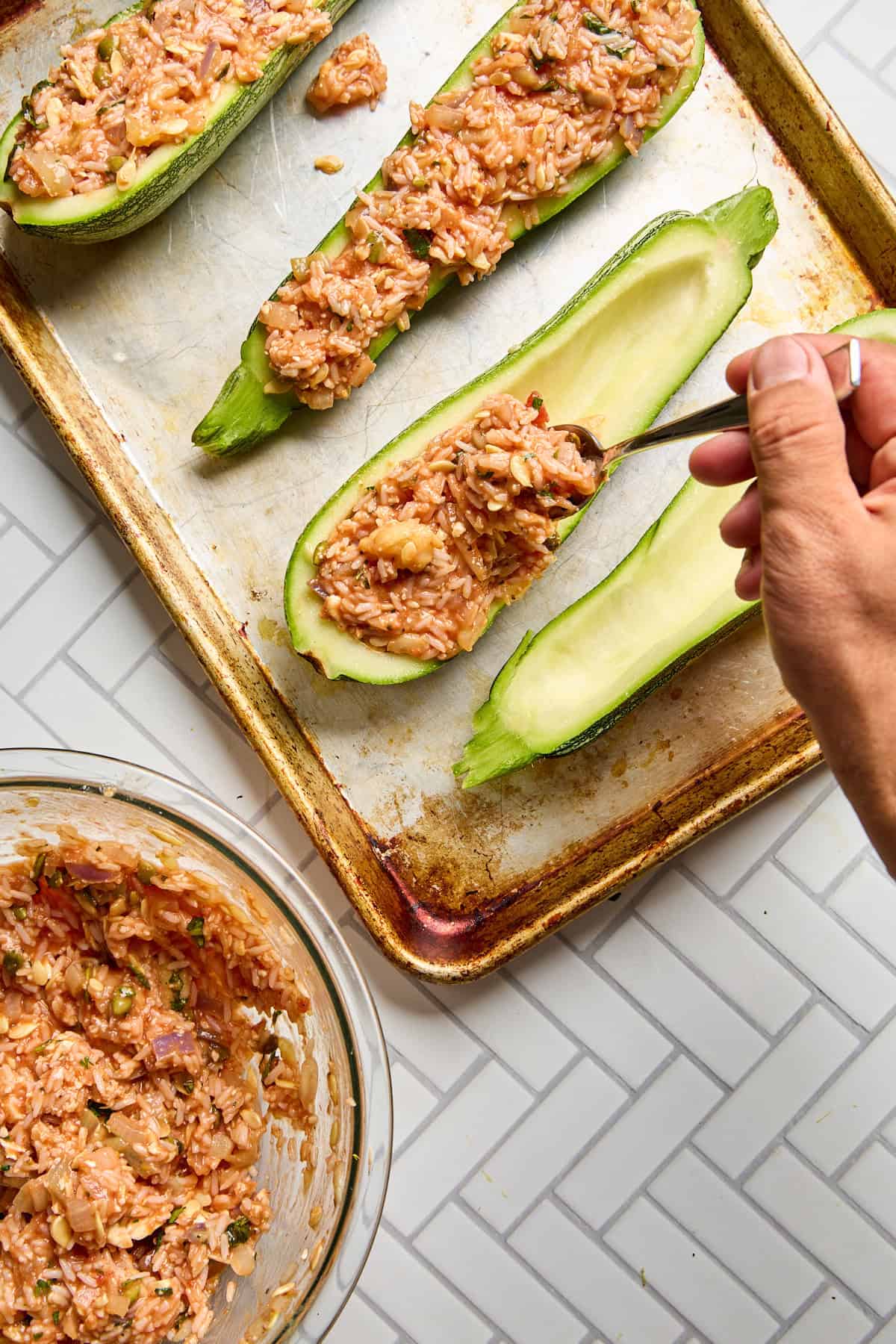 rice filling being scooped into zucchini