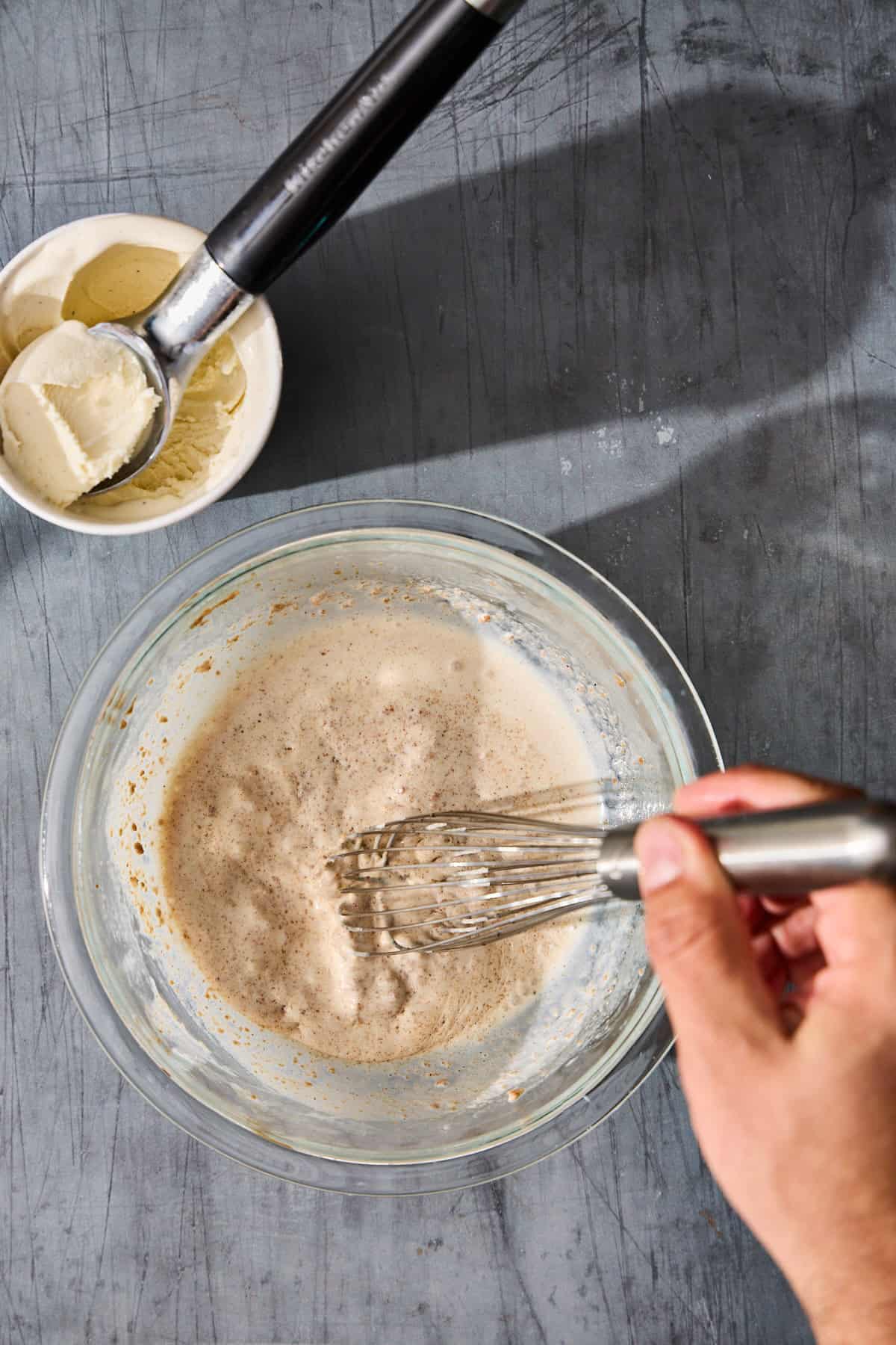 ice cream being whisked into the batter in a bowl