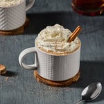 a mug of hot buttered rum with a cinnamon stick