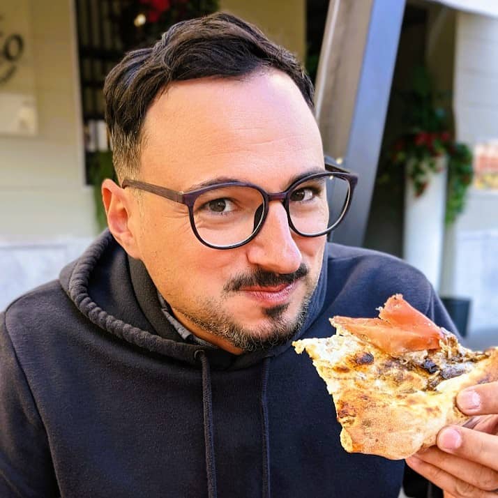 man eating pizza in italy