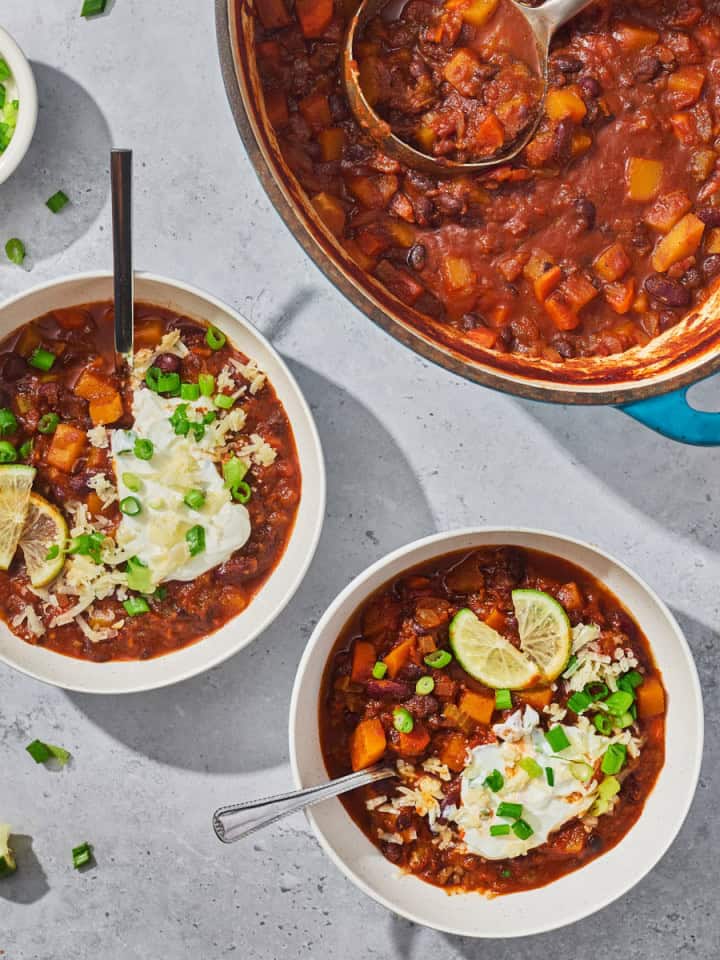 bowls and a pot of chili with vegetables