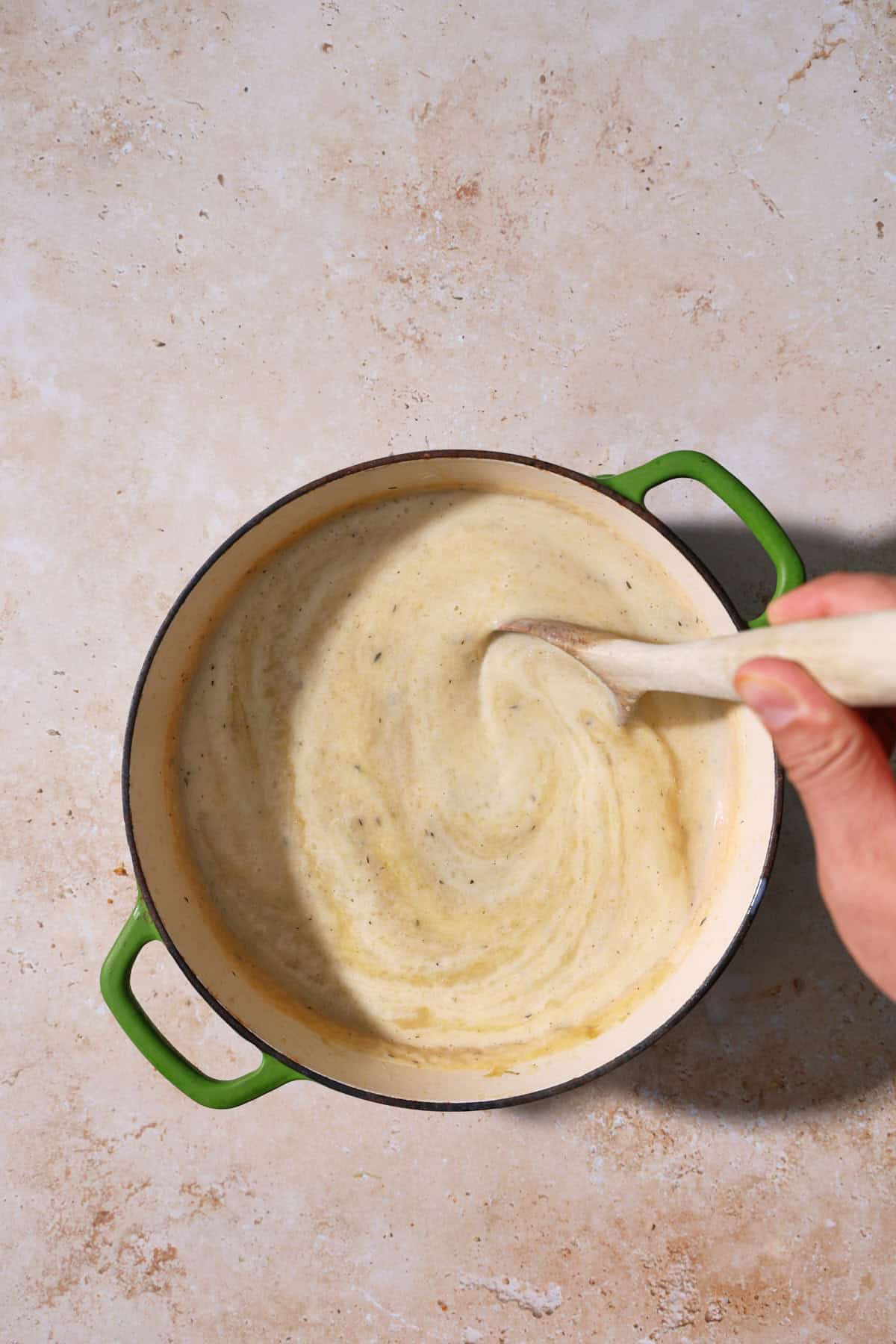 cream being stirred into the celery leek soup