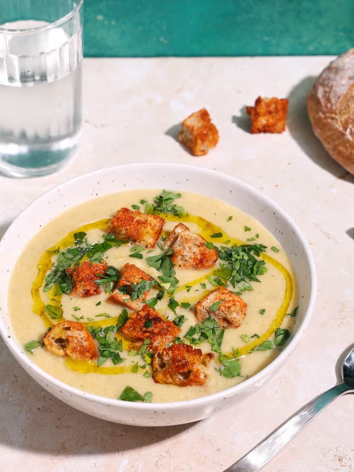 a bowl of soup with celery and leeks, and potatoes
