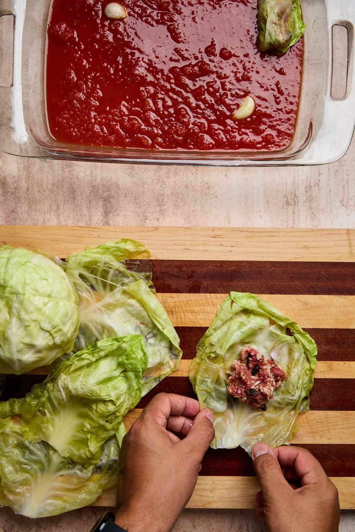 Rolling cabbage leaf around beef and rice filling for golumpki
