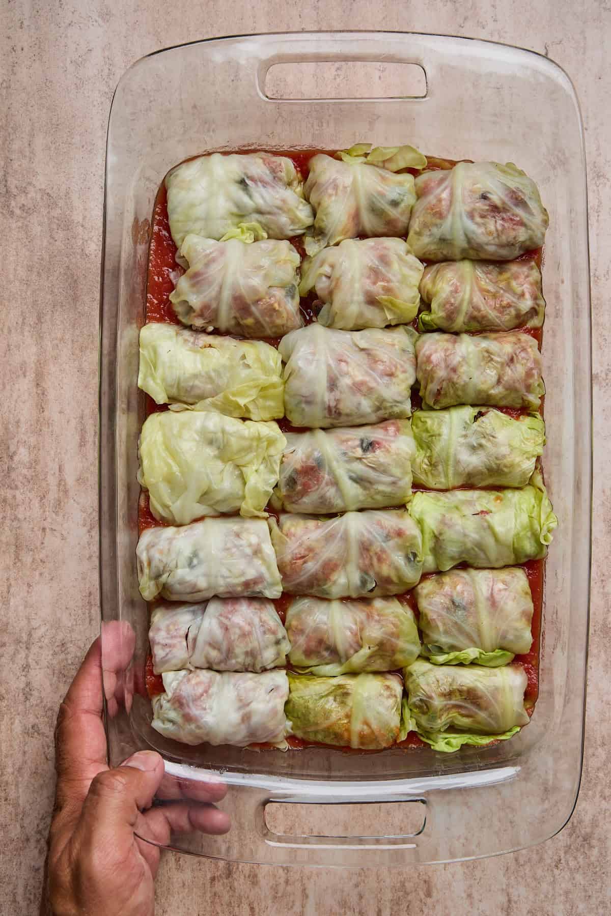 Baking dish of Polish golumpki stuffed cabbage rolls with tomato sauce