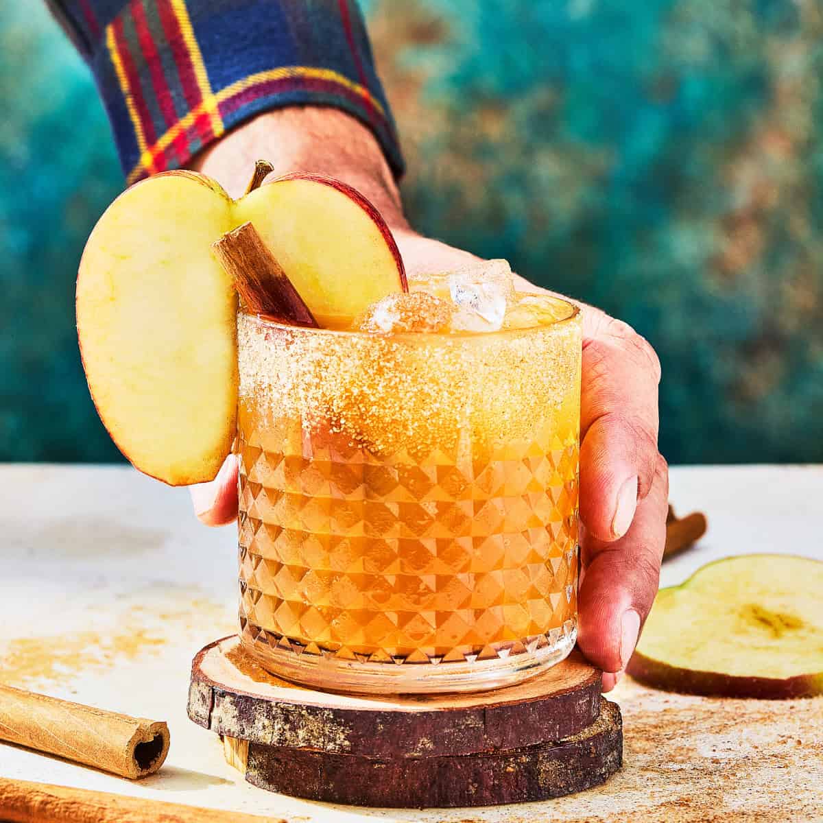a hand serving a cider cocktail