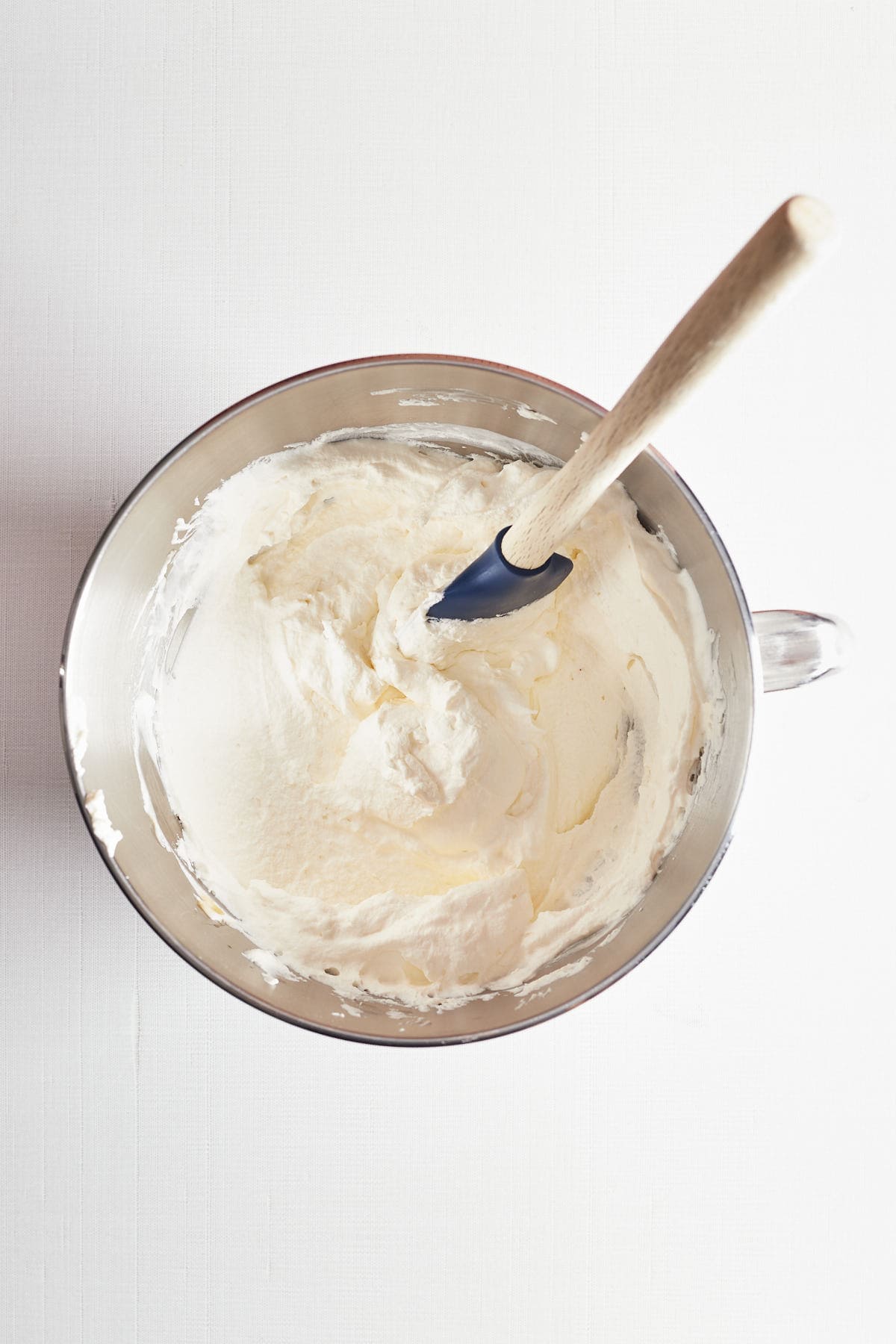 whipped cream in a mixing bowl with a spatula