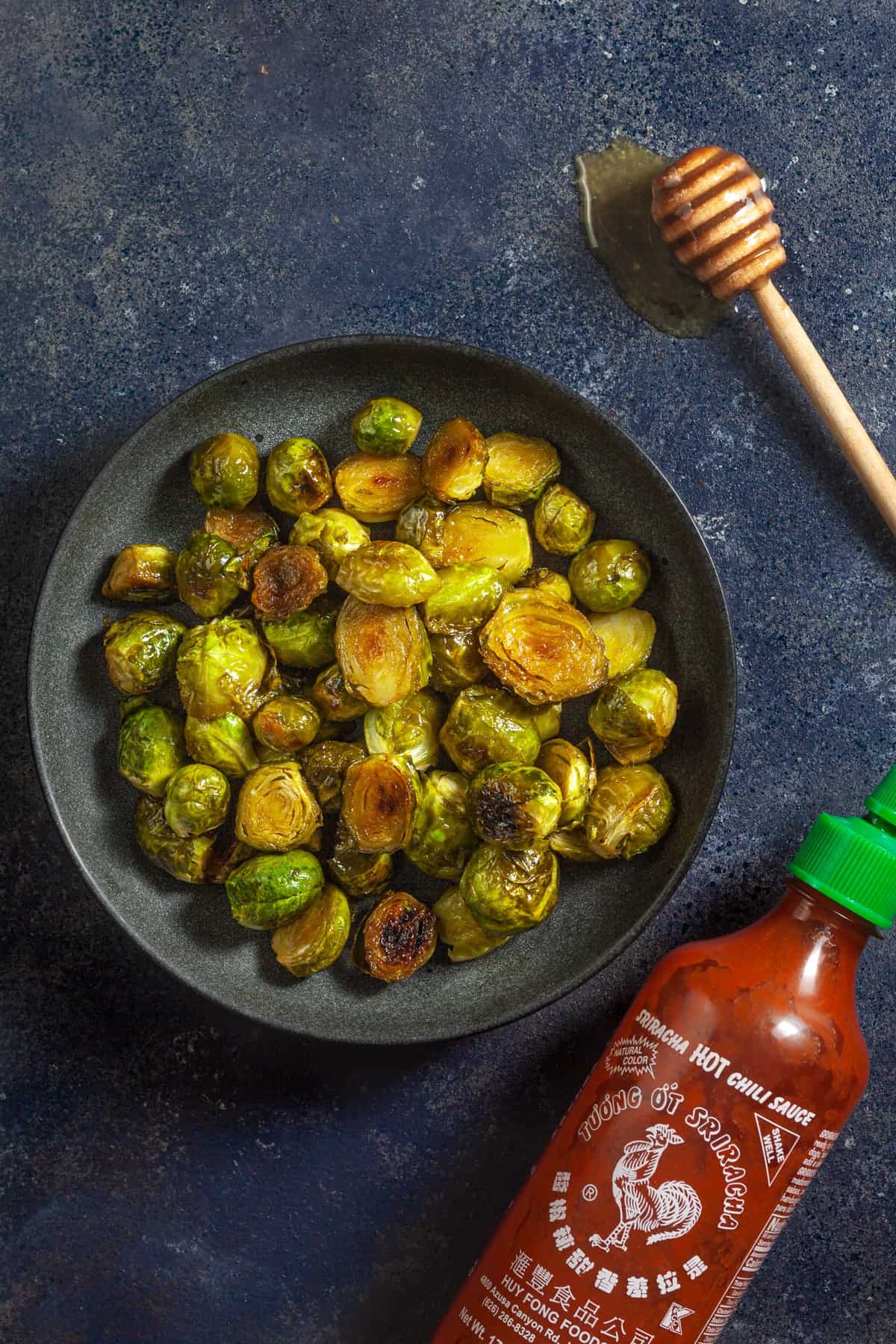 brussels sprouts in a plate with honey and sriracha