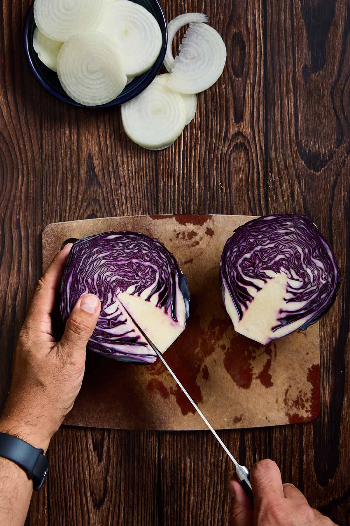 thecore of a red cabbage being cut out with a knife