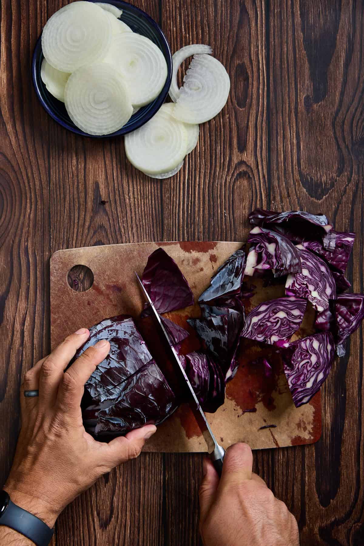 red cabbage being sliced on a cutting board