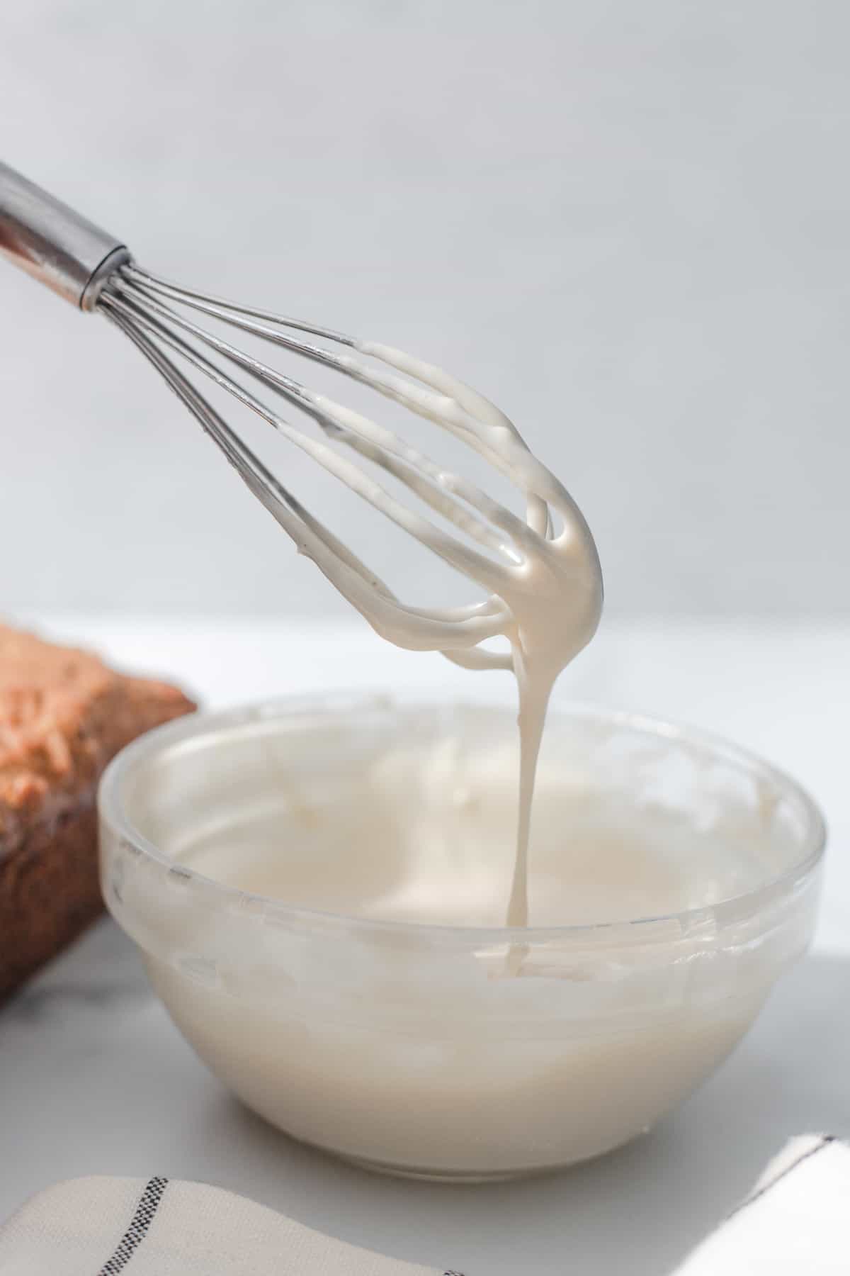 maple cream cheese icing being whisked in a bowl