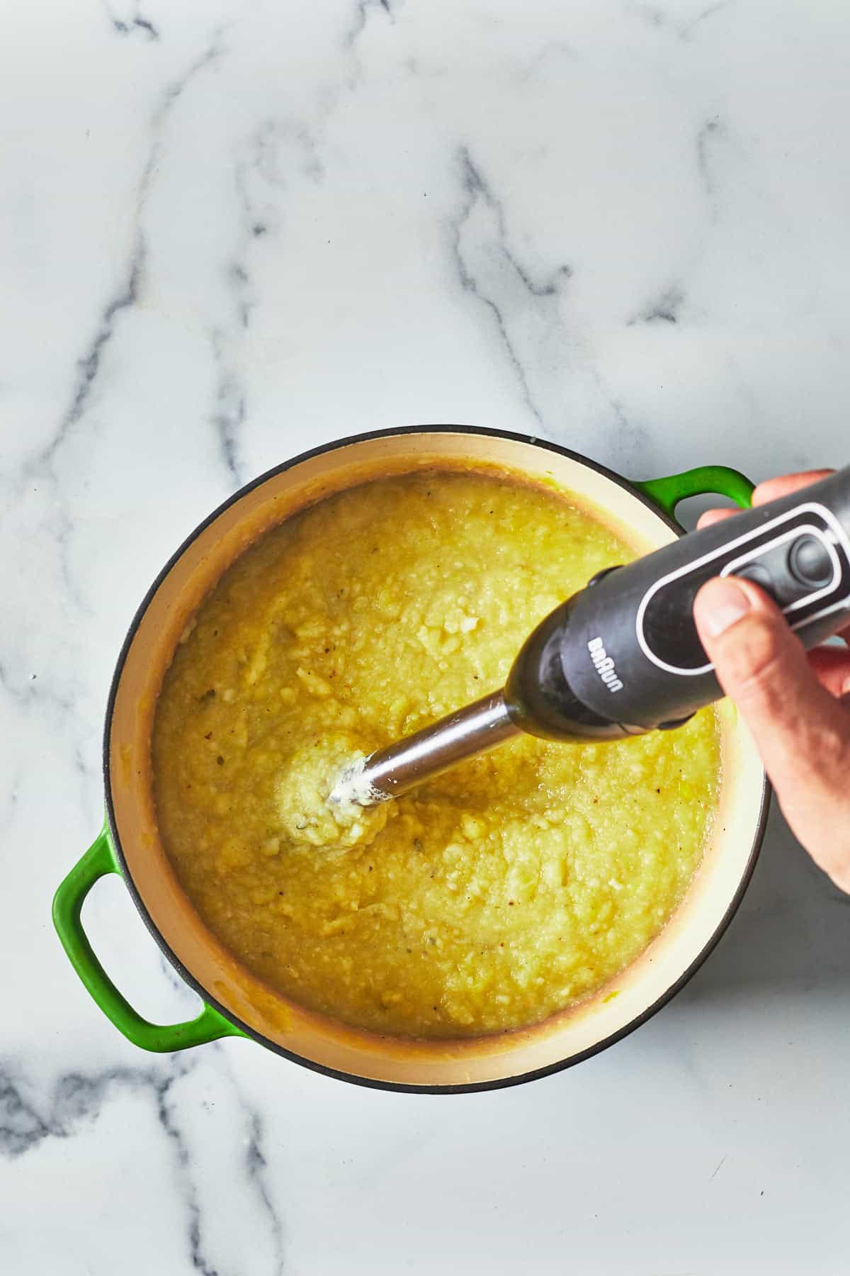 soup being pureed with an immersion blender