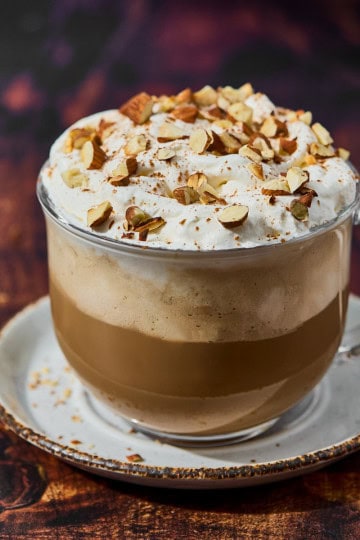 mug of amaretto latte with almonds and whipped cream