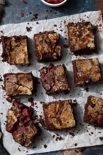 brownies on parchment with knife and cherries