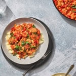plate of chorizo and beans with a bowl of mashed potatoes
