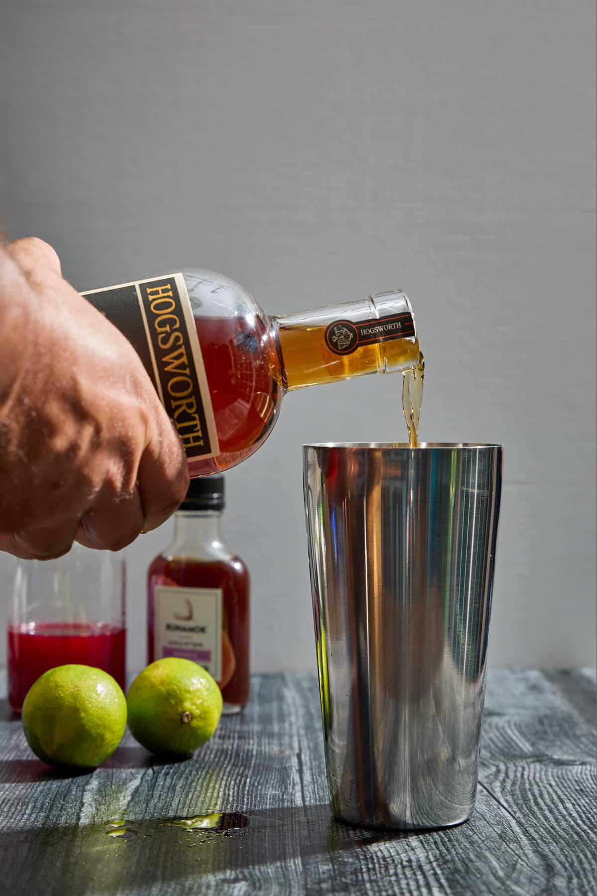 bourbon being poured into a cocktail shaker