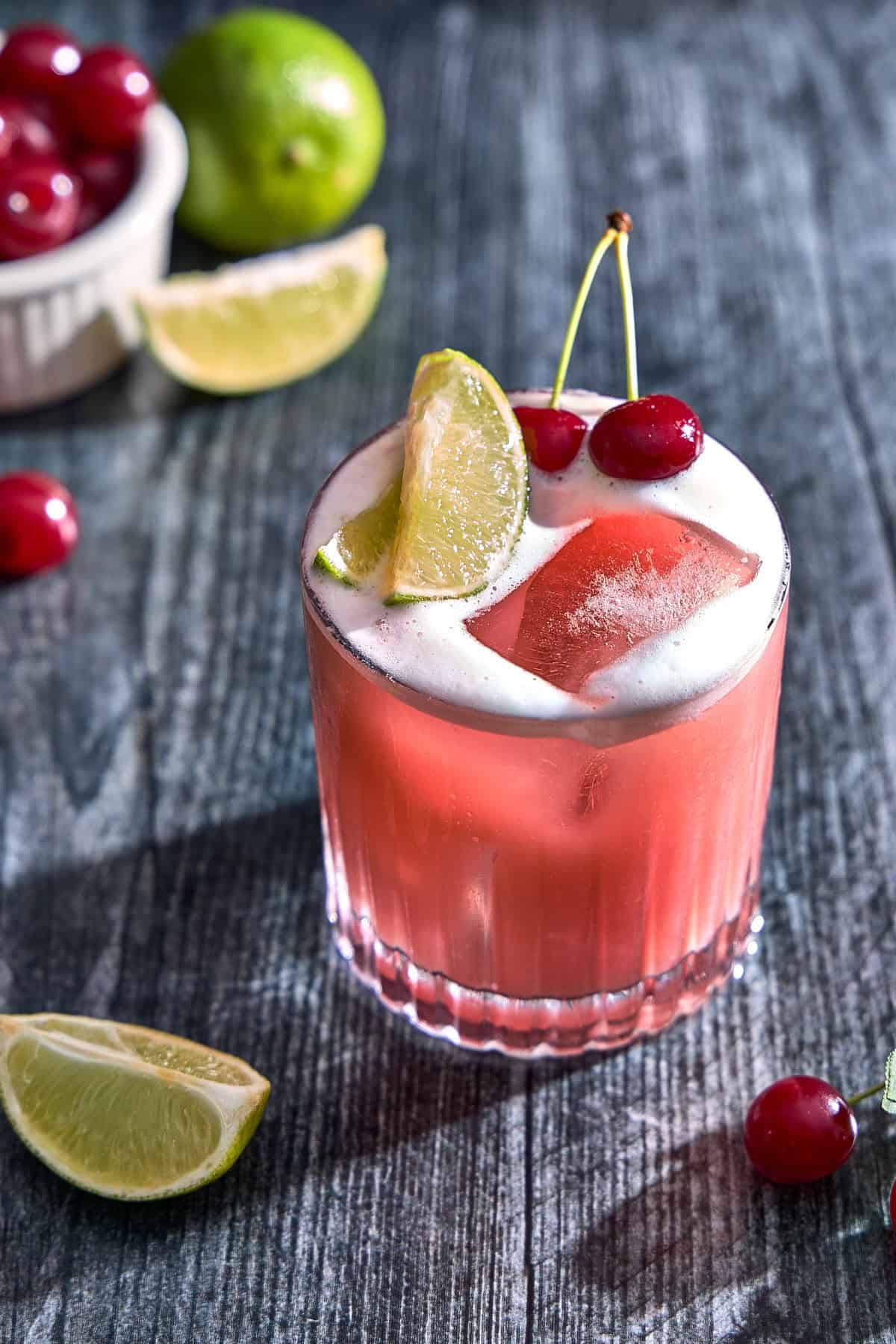 a glass with cherry whiskey sour