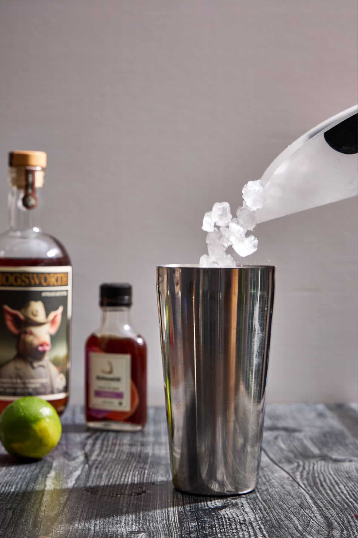 ice being added to a cocktail shaker