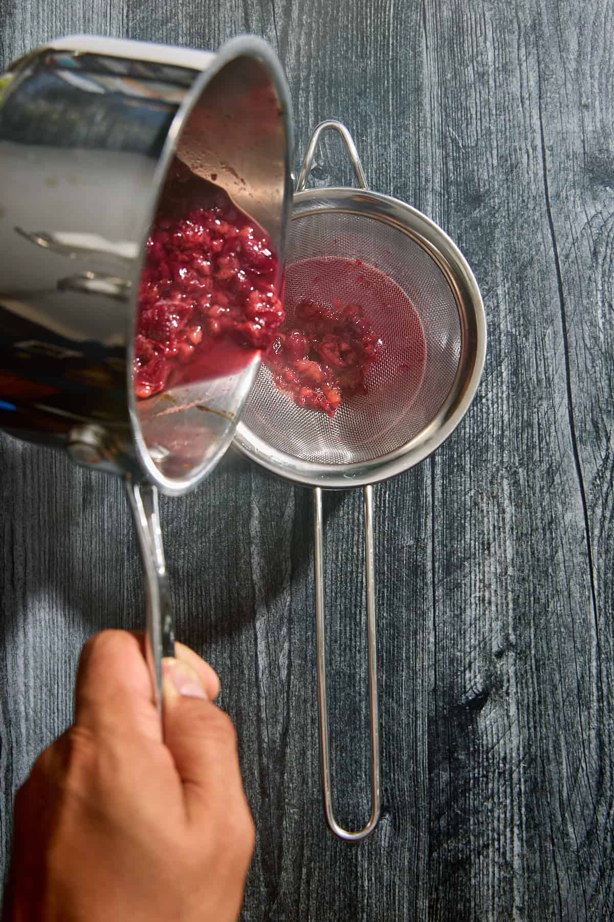 cherries being strained into a sieve