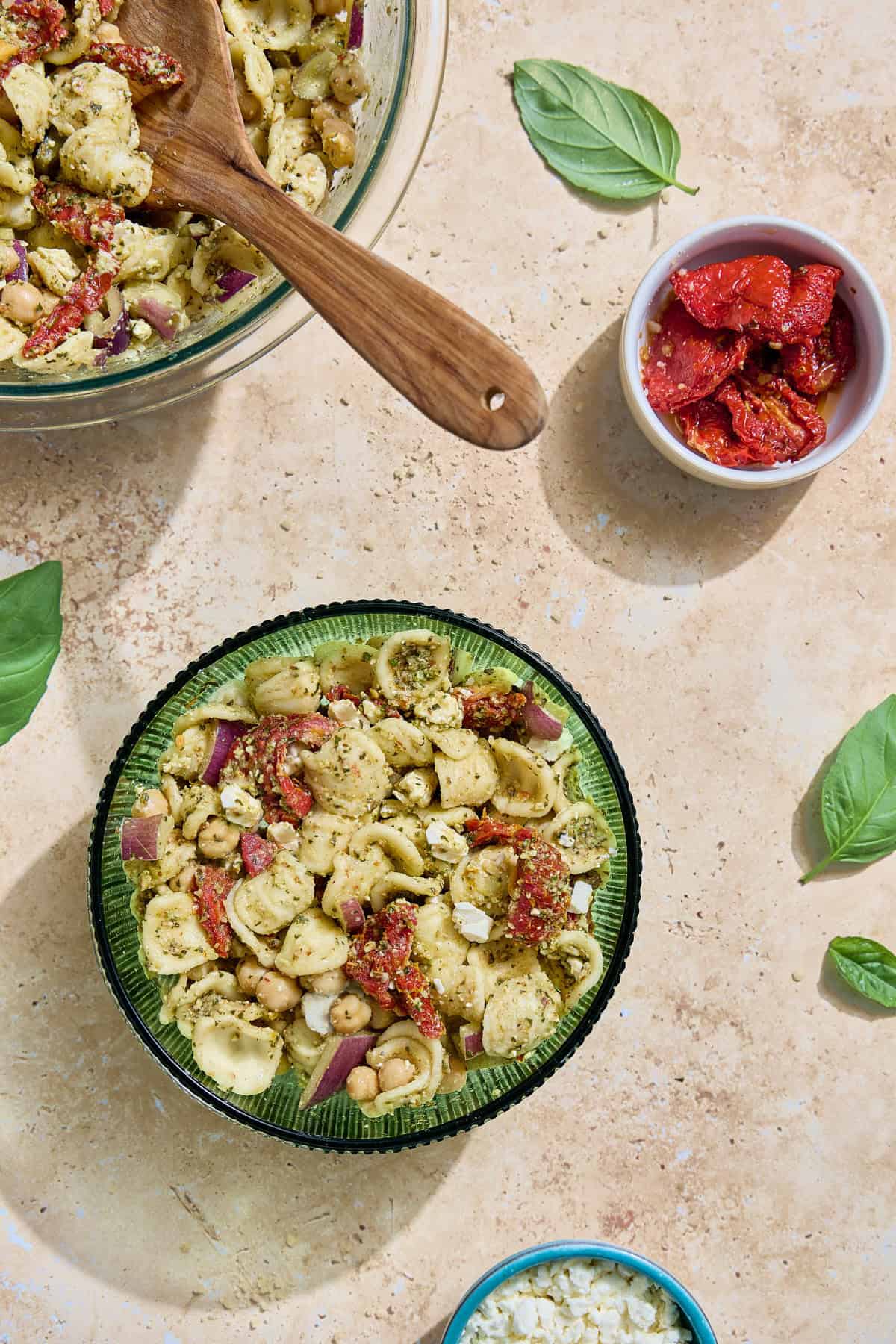 bowls of pasta salad with basil and tomatoes