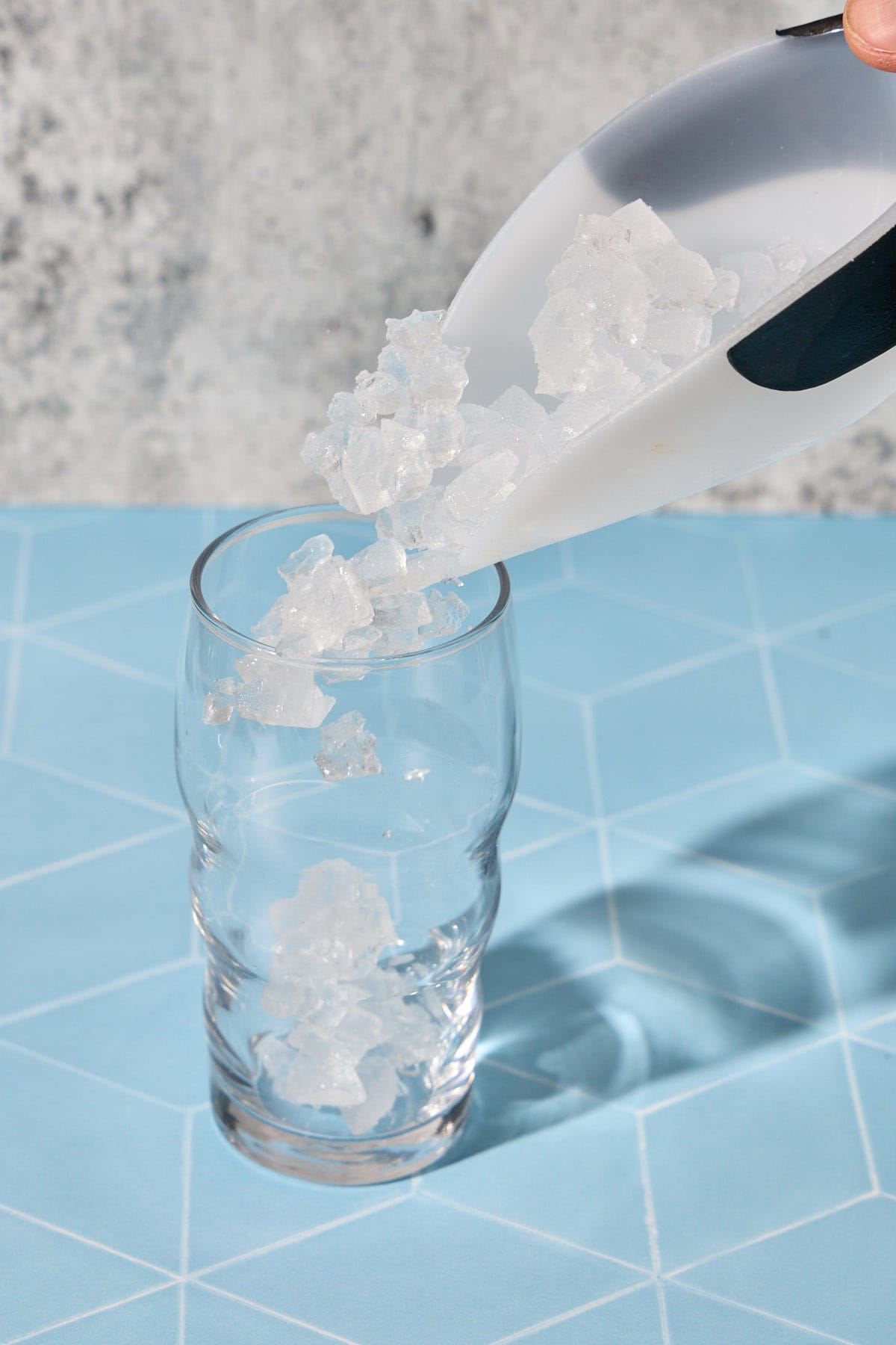 a scoop of ice being poured into a glass