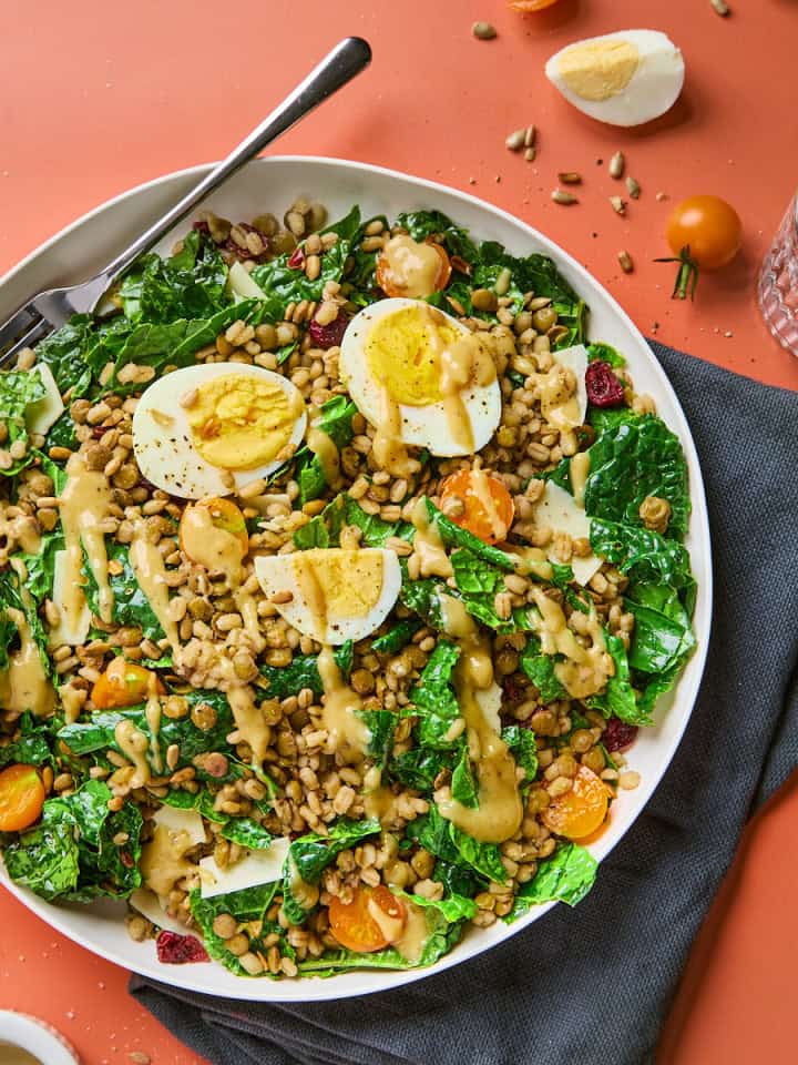 a plate of kale and lentil salad with barley and eggs