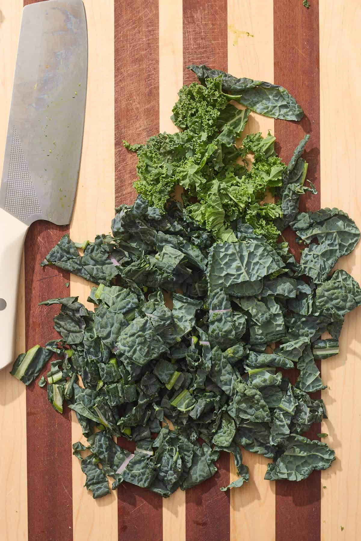 kale leaves roughly chopped on cutting board with knife