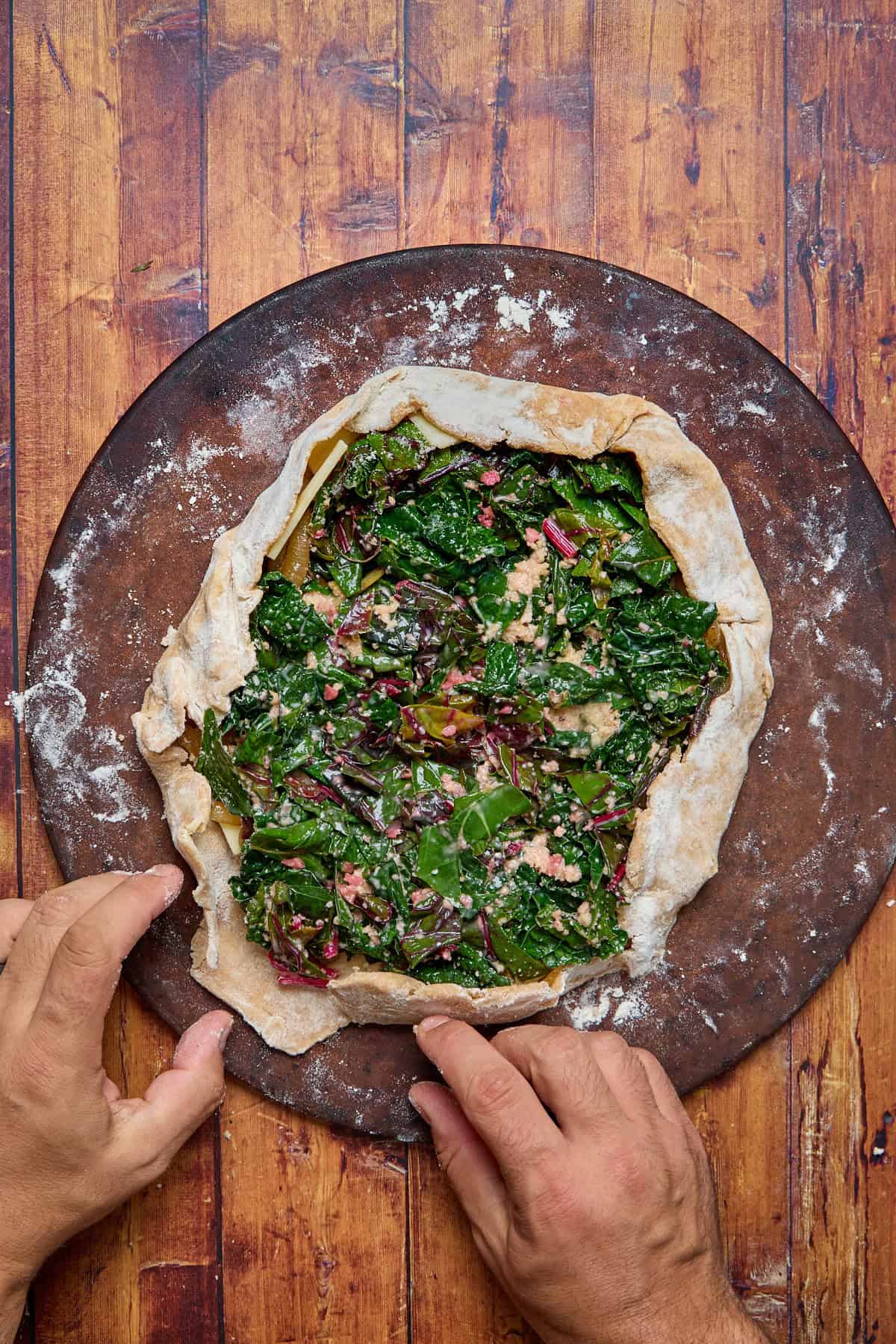 galette dough being shaped around the greens