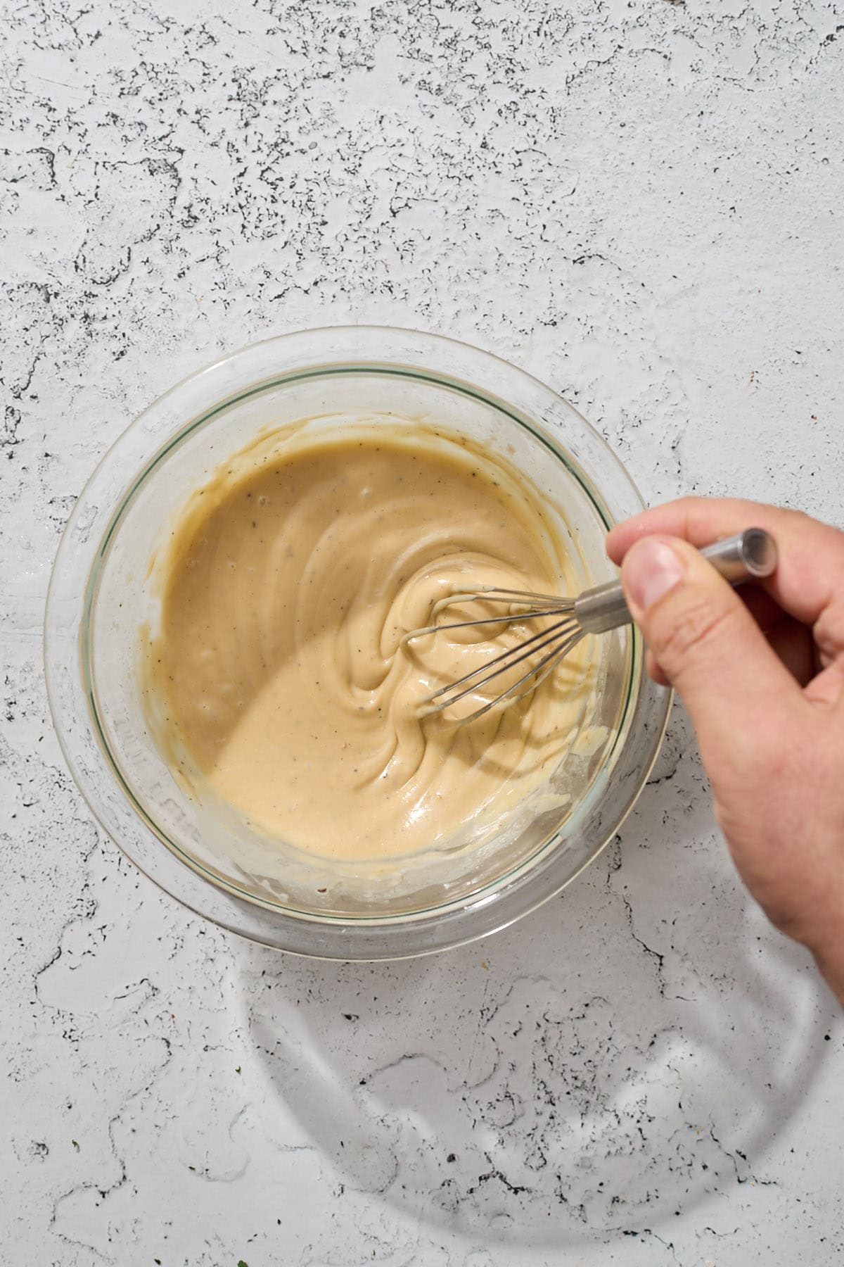 tahini dressing being whicked in a bowl