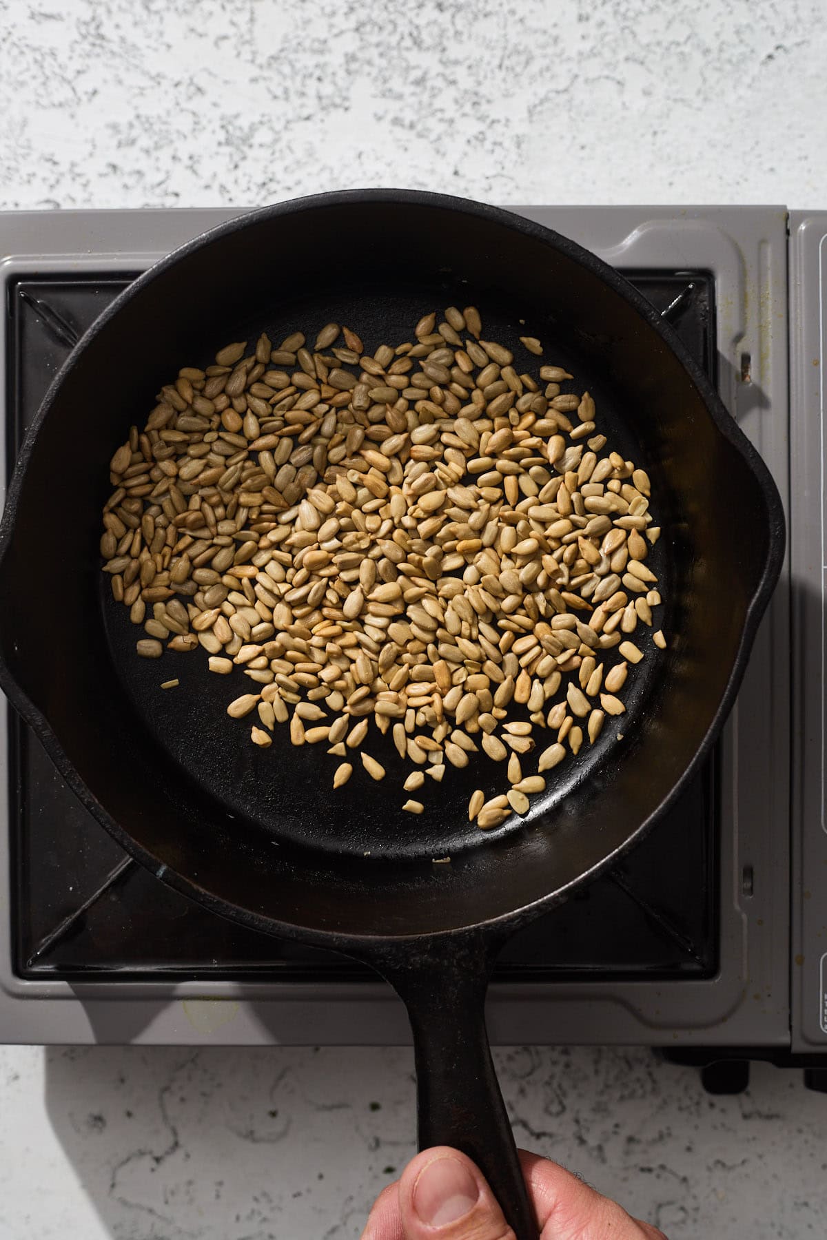 sunflower seeds toasting in a pan