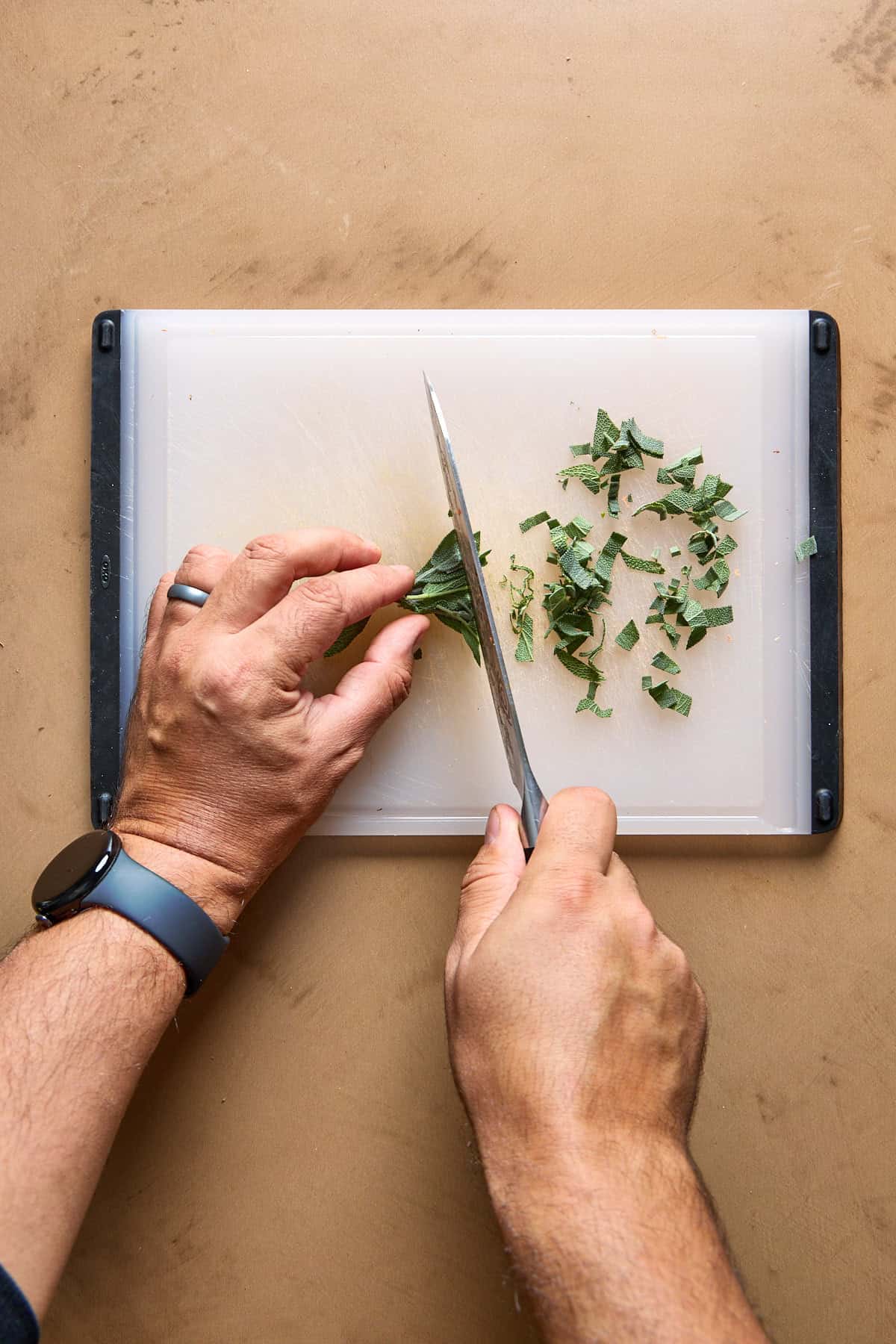 sage being chopped on a cutting board