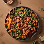 a plate of sweet potatoes and green beans with pecans and butter