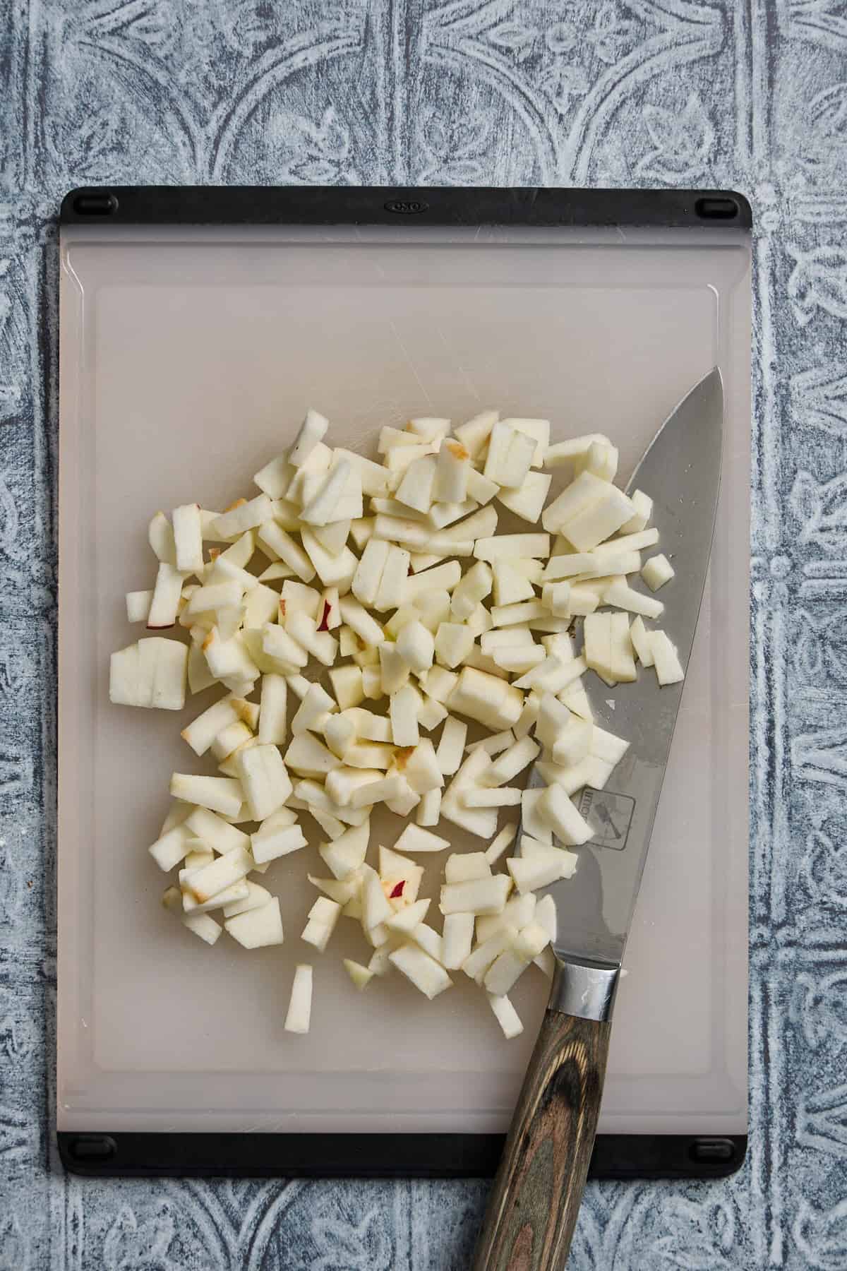 chopped apple on a cutting board with knife