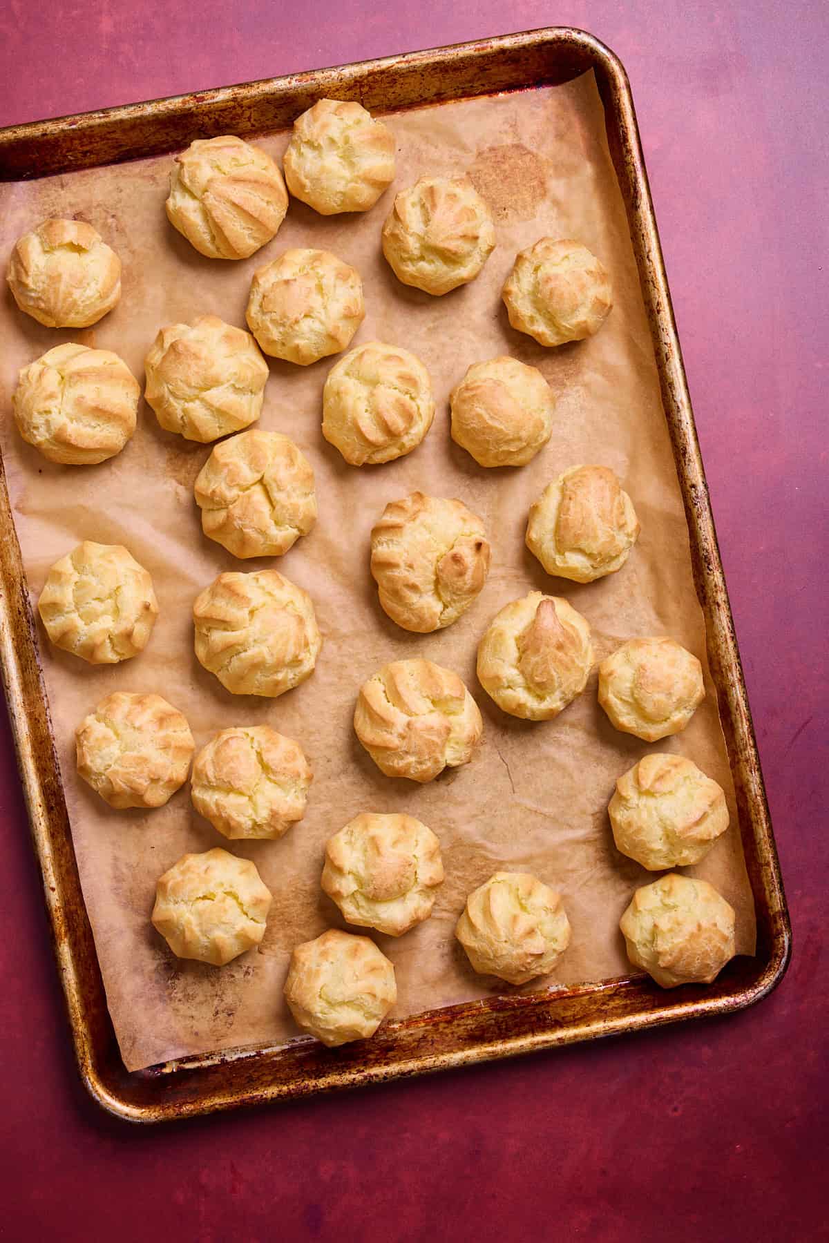 baked cream puffs on a baking sheet