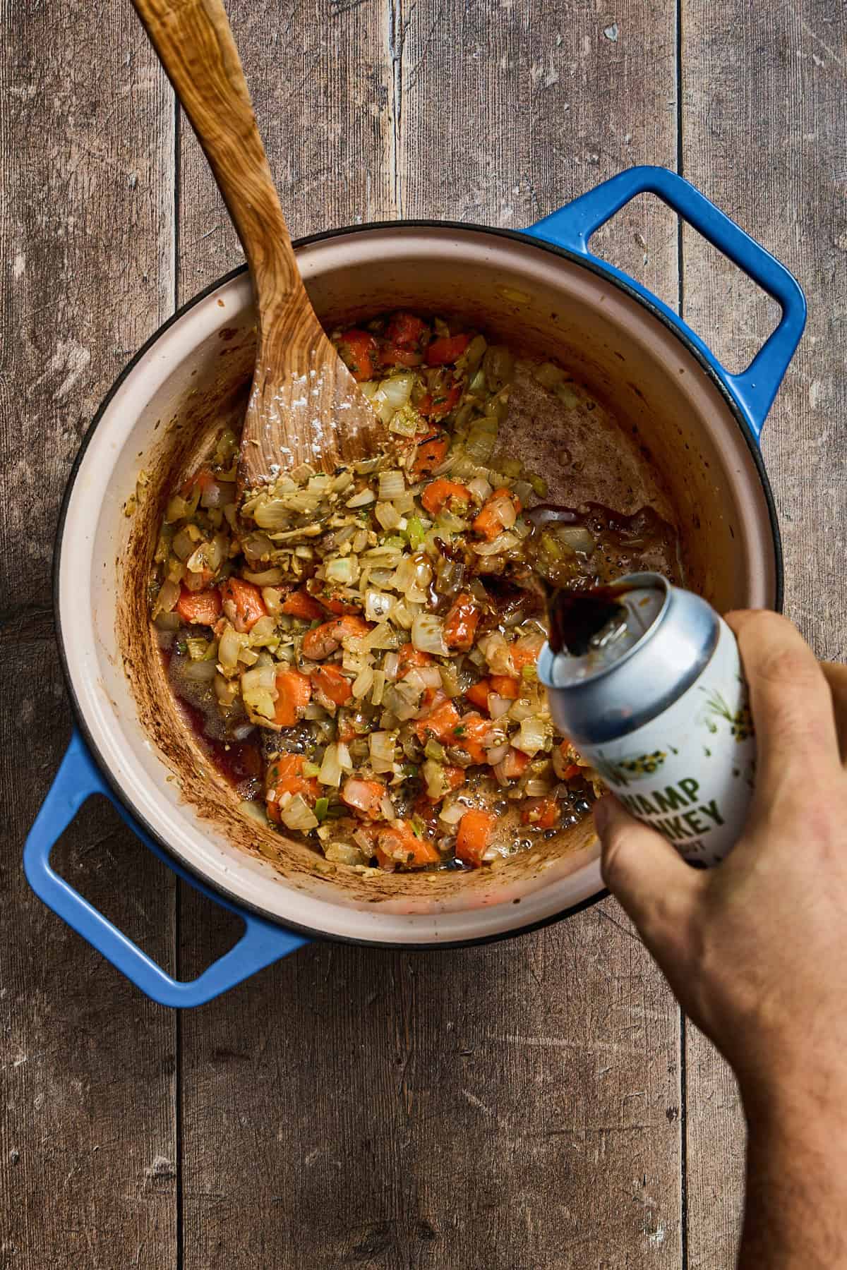 stout being poured into the pot of stew
