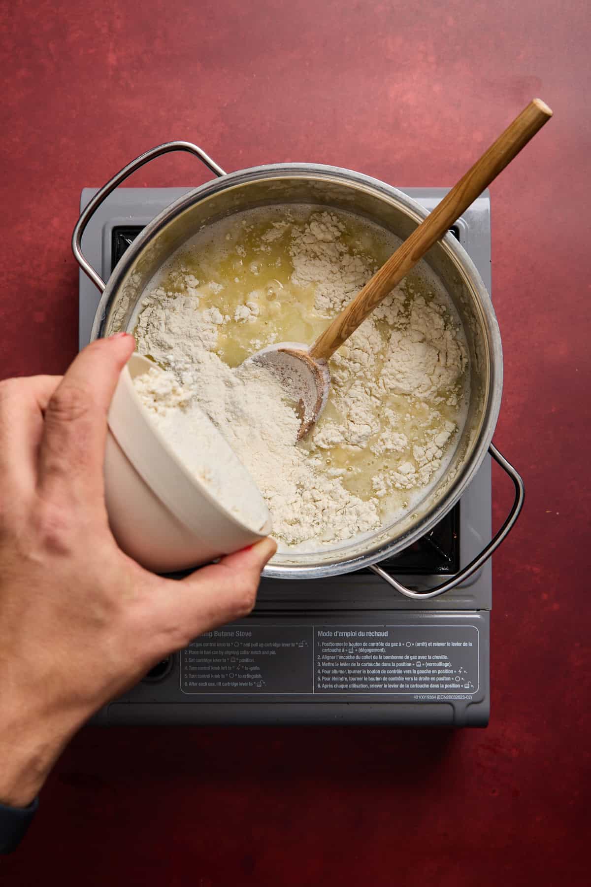 flour being added to a pan of melted butter