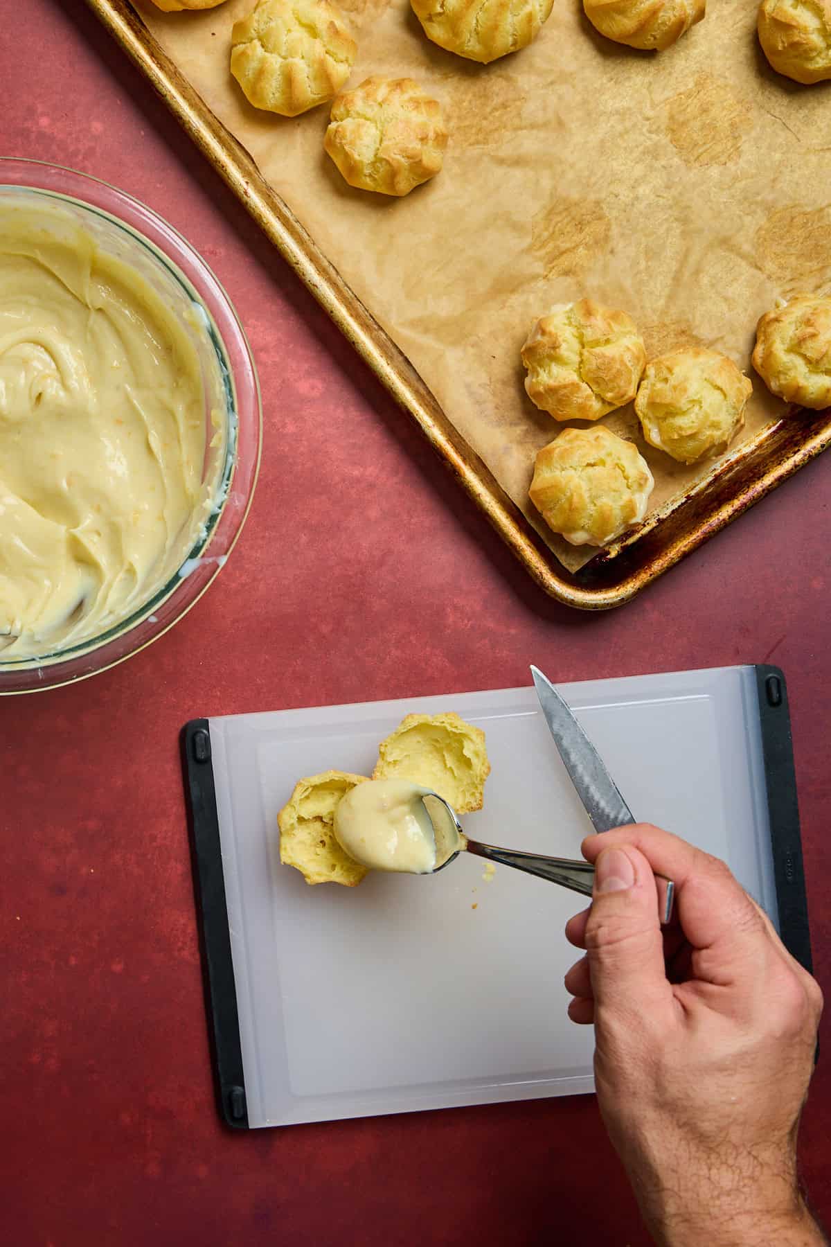 pastry cream being scooped onto a cream puff