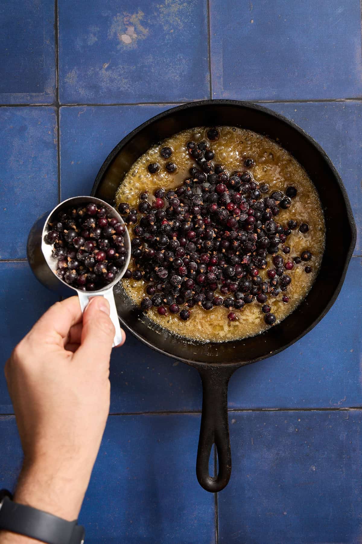 blackcurrants being poured over caramel