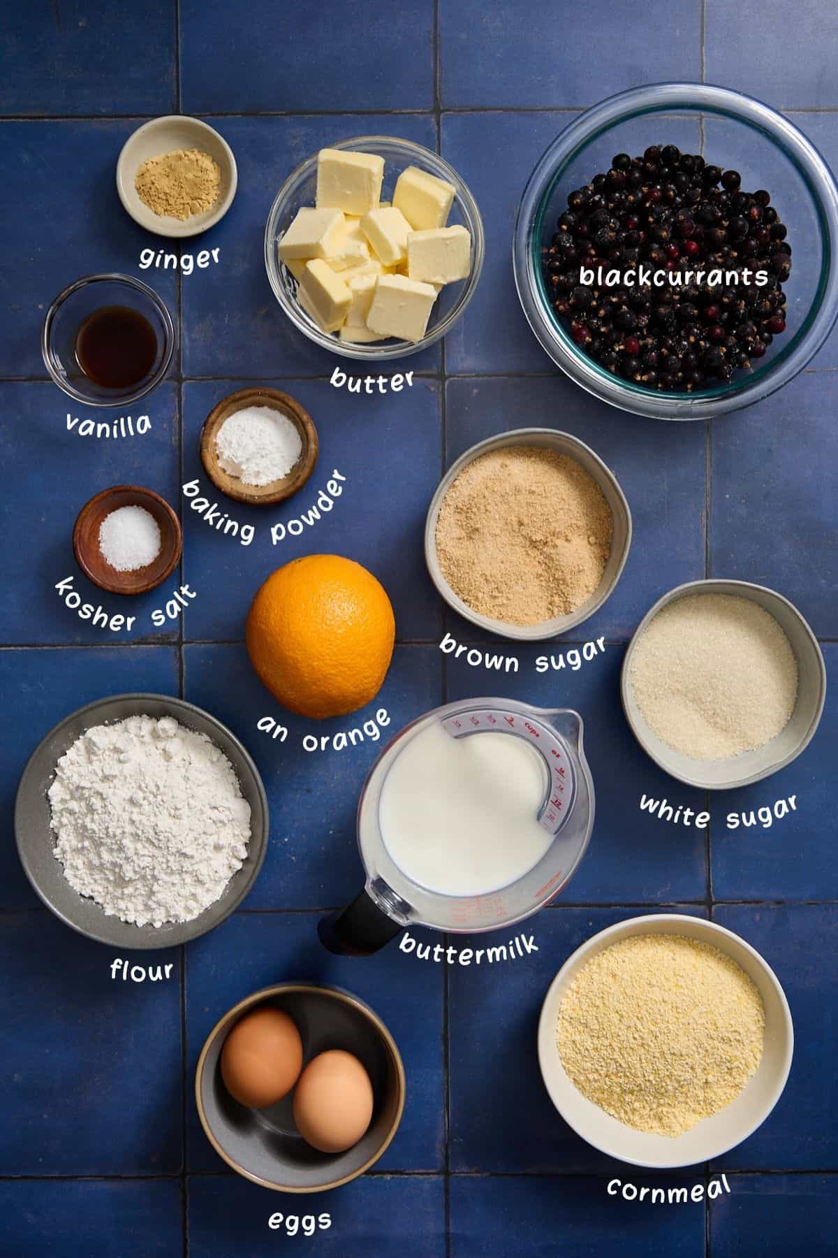 ingredients for making the black currant cake on a blue tiled counter
